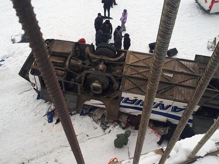 Der von einer Brücke gestürzte Bus liegt auf dem zugefrorenen Fluss.
