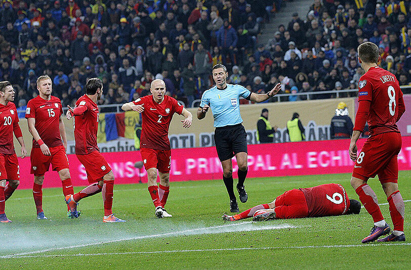 Im WM-Qualispiel gegen Rumänien wurde Polens Kapitän Robert Lewandowski von einem Knallkörper getroffen. Nach kurzer Behandlung spielte der Bayern-Star weiter - und erzielte noch einen Doppelpack. Die Bilder.