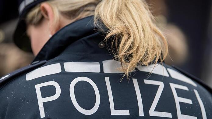 Der Pferdeschwanz einer Polizisten fällt auf ihre Jacke.