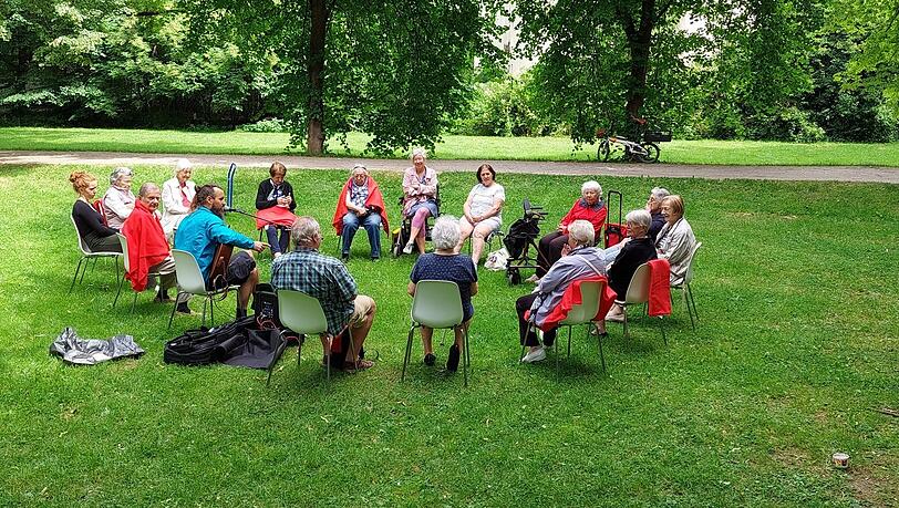 Im kleinen Behrpark in Berg am Laim: Die Gruppe auf der Wiese trällert bekannte Lieder.
