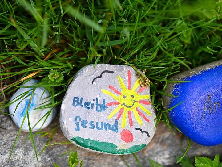 Bemalte Steine an einem Wegesrand.