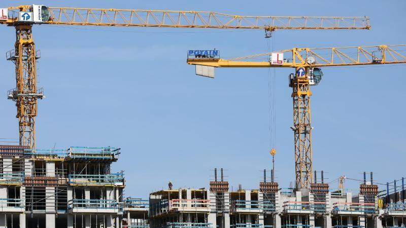 Kräne stehen auf einer Baustelle für mehrstöckike Wohnhäuser. Foto: Christian Charisius/dpa/Archivbild