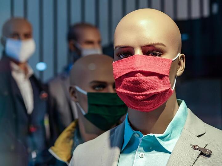 Schaufensterpuppen mit Mundschutz stehen in einem Geschäft. Foto: Jens Kalaene/dpa-Zentralbild/dpa/Symbolbild