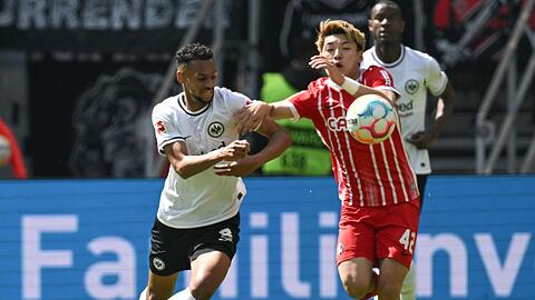 Frankfurts Djibril Sow (l) und Freiburgs Ritsu Doan kämpfen um den Ball.