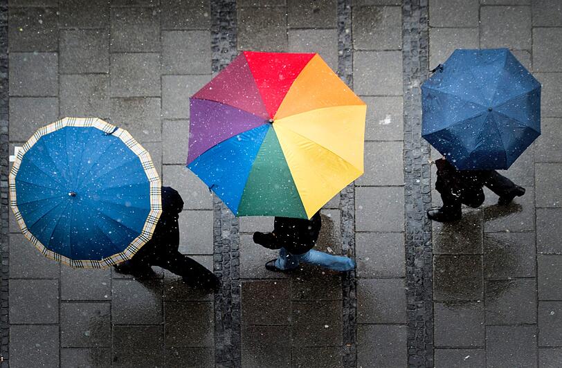 In der Münchner Innenstadt bleibt es erstmal beim Schneeregen. Da hilft nur ein Schirm.