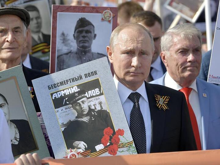Wladimir Putin hält ein Porträt seines Vaters Wladimir Spiridonowitsch Putin.