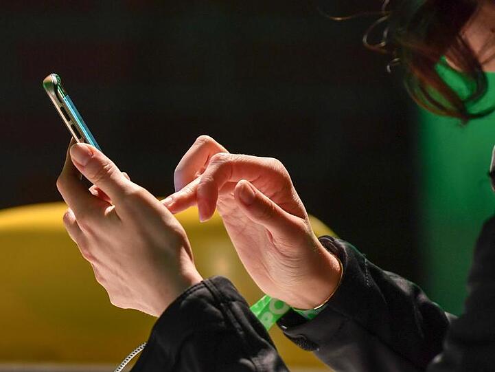 Eine Frau tippt auf ihrem Smartphone. In Sachen Online-Banking kommen auf die Bankkunden einige Änderungen zu.
