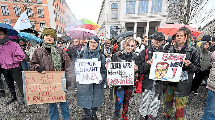 Demonstranten stehen mit Plakaten bei einem Protest gegen das Gender-Verbot auf dem Gärtnerplatz.