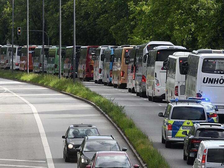 Reisebusse fahren bei einer Demonstration in einem Korso.