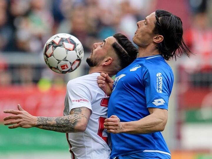 Marco Richter vom FC Augsburg (l) und Nico Schulz von Hoffenheim im Zweikampf um den Ball. Foto: Matthias Balk
