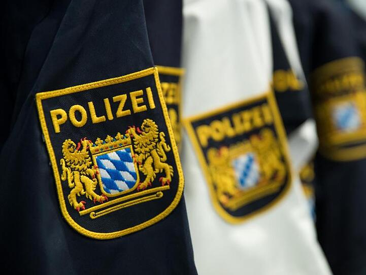 Polizeiuniformen tragen das Logo der bayerischen Polizei. Foto: picture alliance / Daniel Karmann/dpa/Archivbild