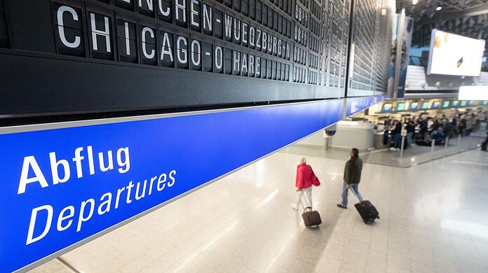 Reisegäste gehen an einem Flughafen zum Abflugterminal.