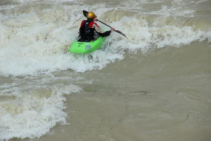 Hochwasser für die einen, perfekte Wellen für die anderen. Waghalsig tummeln sich Sportler in der Isar.