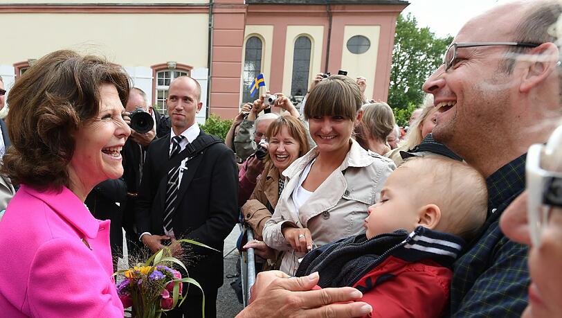 Nur der kleine Bub verschläft diesen hohen und zugleich fröhlichen Besuch: Königin Silvia von Schweden freut sich über die Blumen. Nur der kleine Bub verschläft diesen hohen und zugleich fröhlichen Besuch: Königin Silvia von Schweden freut sich über die Blumen.