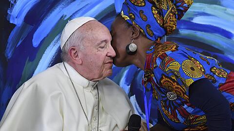 Papst Franziskus scheint es zu genießen, dass diese Frau ihn zur Begrüßung küsst. Obwohl er selbst zölibatär lebt, entspricht das seiner Überzeugung, dass Menschen auch durch Gesten der Zärtlichkeit miteinander kommunizieren sollten.