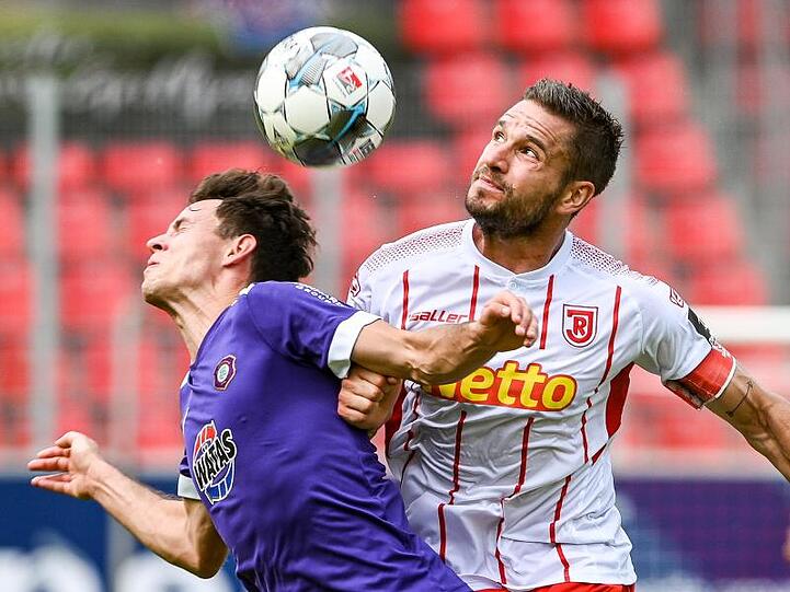 Clemens Fandrich von Erzgebirge und Marco Grüttner von Regensburg (l-r.) im Zweikampf um den Ball. Foto: Armin Weigel/dpa