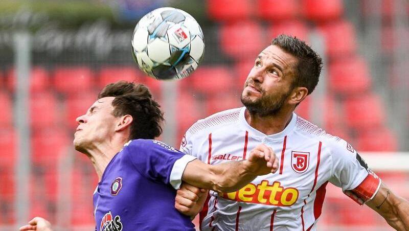 Clemens Fandrich von Erzgebirge und Marco Grüttner von Regensburg (l-r.) im Zweikampf um den Ball. Foto: Armin Weigel/dpa Clemens Fandrich von Erzgebirge und Marco Grüttner von Regensburg (l-r.) im Zweikampf um den Ball. Foto: Armin Weigel/dpa