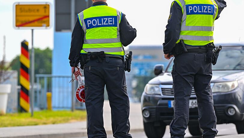 Beamte der Bundespolizei stehen an der deutschen Grenze.