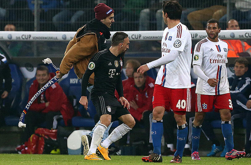 Am Mittwochabend unterbricht wieder einer Störenfried das Pokalspiel zwischen dem HSV und dem FC Bayern. Erst schlägt er Franck Ribéry seinen Schal ins Gesicht...