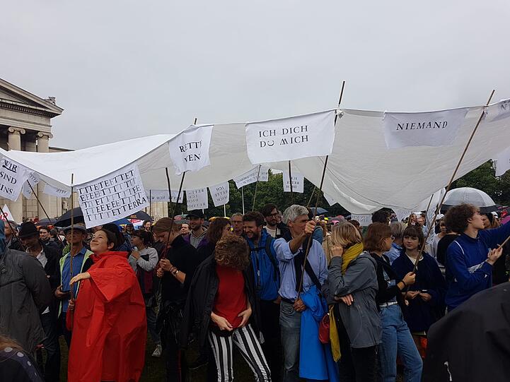 Die Teilnehmer der Demo sind gut vorbereitet. Hier ein Regendach und Banner in einem.