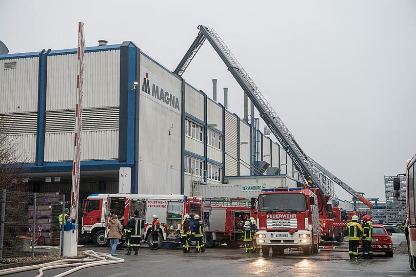 Einsatzkräfte der Feuerwehr stehen am 24.02.2015 in Straubing  vor einer Werkshalle. Nach Angaben der Polizei war es im ersten Stock einer Kfz-Werkstatt zu dem Brand gekommen. Verletzt wurde bei dem Feuer offensichtlich niemand.
