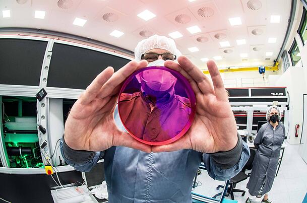 Ein Wissenschaftler zeigt eine Laserlinse. Die LMU arbeitet eng mit der M&uuml;nchner Firma Marvel Fusion zusammen, die eine laserbasierte Kernfusion entwickelt.