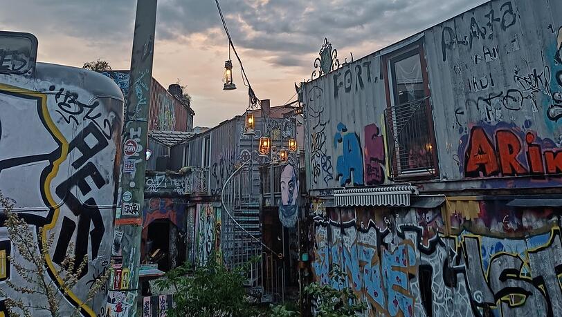 Ein buntes Containerdorf im sommerlichen Abendlicht: Eindruck aus dem Bahnwärter Thiel.