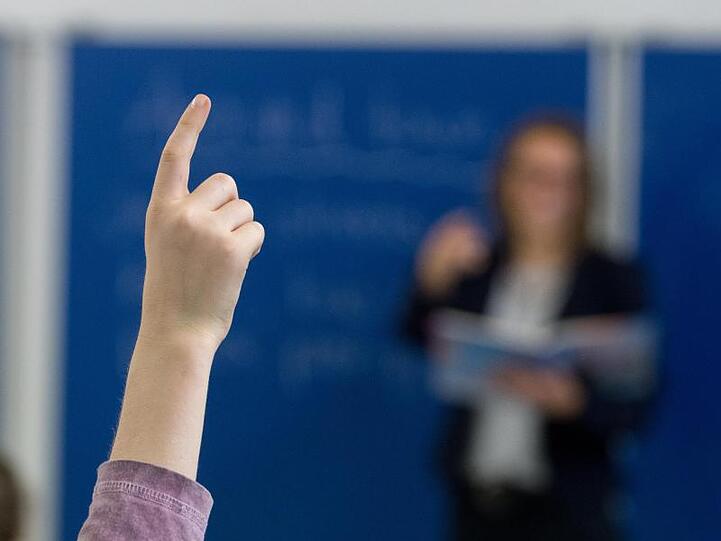 Ein Schüler an einem Gymnasium meldet sich im Unterricht. Foto: Armin Weigel/Archiv