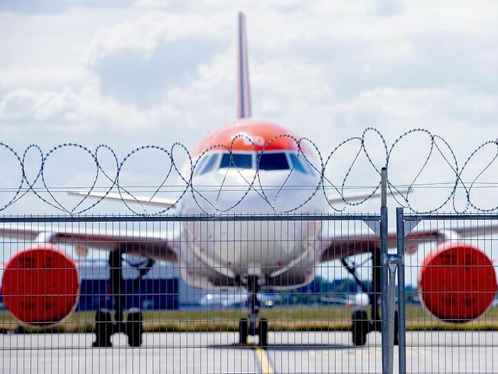 Ein geparktes Flugzeug mit abgehängten Triebwerken steht nahe der Baustelle des Vorfelds E2 auf dem Hauptstadtflughafen Berlin Brandenburg "Willy Brandt" (BER).