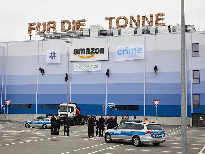Greenpeace-Aktivisten seilen sich am Gebäude der Amazon Logistik Winsen GmbH ab.