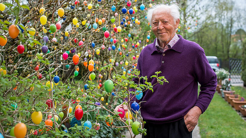 Walter Aumüller hängt in seinem Garten 1100 bunte Osterei auf.