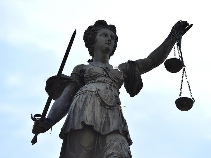 Eine Bronzestatue der Justitia steht unter freiem Himmel. Foto: Arne Dedert/picture alliance/dpa/Symbolbild
