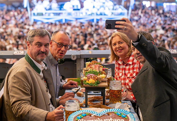 Bundeskanzler Friedrich Merz (2.v.l.), Bärbel Bas und Lars Klingbeil besuchen auf Einladung von Markus Söder das Oktoberfest und sitzen im Festzelt Schottenhamel.