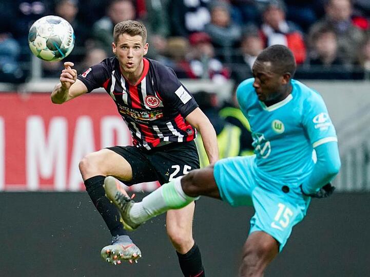 Frankfurts Erik Durm (l) und Wolfsburgs Jerome Roussillon kämpfen um den Ball.