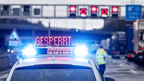 Auf einem Polizeifahrzeug leuchtet die Aufschrift "Gesperrt".