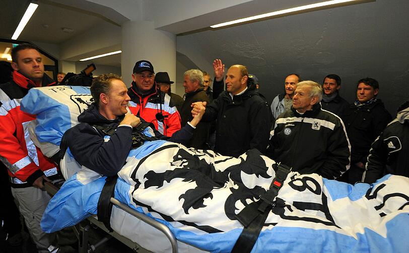 Olaf Bodden wird auf einem Krankenbett auf den Rasen des Grünwalder Stadions gefahren.