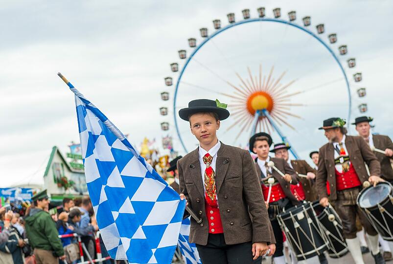 Trotz Nieselwetters rollten rund 40 Festwagen und Kutschen in dem sieben Kilometer langen Zug mit - und die Trachtler aus der ganzen Welt hatten dabei beste Laune.
