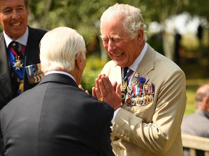 Prinz Charles (r), Prinz von Wales, begrüßt anlässlich des Tages der Kapitulation Japans im Zweiten Weltkrieg am National Memorial Arboretum einen Veteranen.