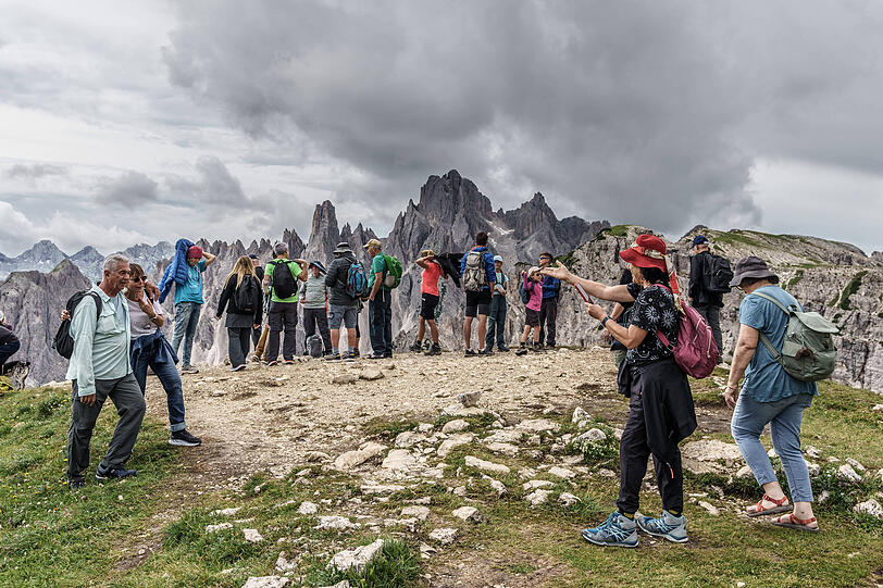Touristen genießen die Aussicht in den Dolomiten, während die Debatte um Overtourism in Südtirol weitergeht. Touristen genießen die Aussicht in den Dolomiten, während die Debatte um Overtourism in Südtirol weitergeht.