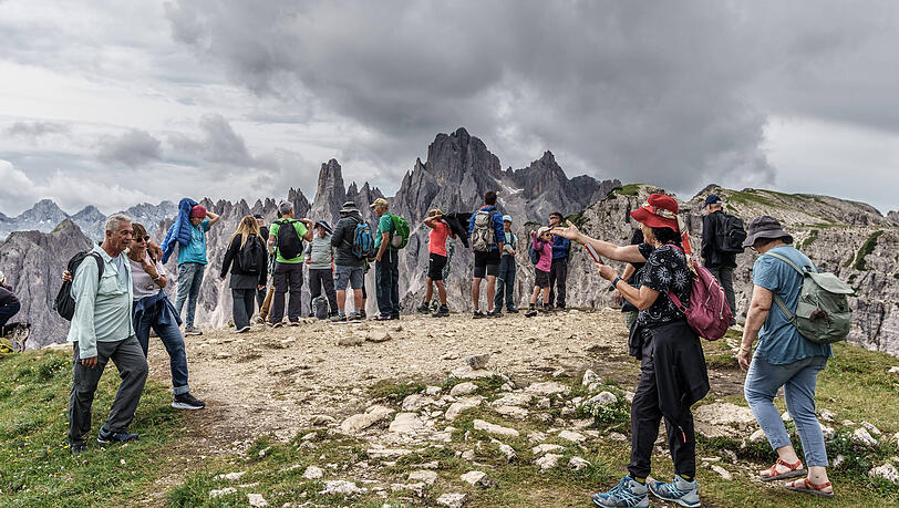 Touristen genießen die Aussicht in den Dolomiten, während die Debatte um Overtourism in Südtirol weitergeht. Touristen genießen die Aussicht in den Dolomiten, während die Debatte um Overtourism in Südtirol weitergeht.