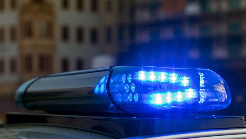 Das Blaulicht auf einem Fahrzeug der Polizei leuchtet in der Dunkelheit.