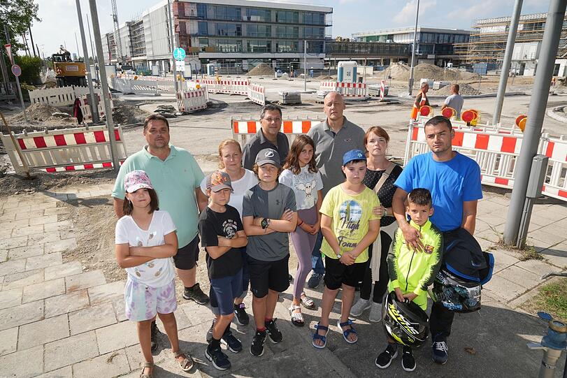 Verärgerte Eltern und Kinder vor der Schulcampus-Baustelle in Riem  - mindestens bis Weihnachten müssen sie in der Schwanthalerstr. zur Schule. (Archiv)