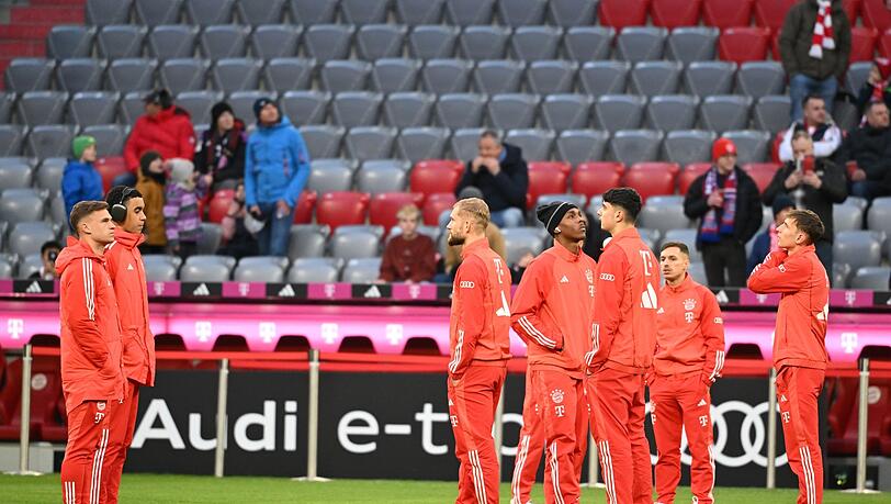 Die Bayern-Spieler um Joshua Kimmich (l) und Jamal Musiala (2.v.l.) begehen vor der Erwärmung den Rasen.