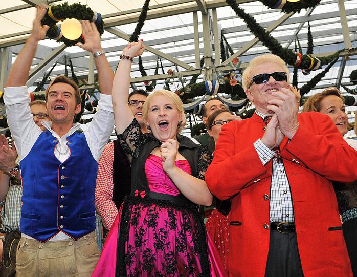 Und sie kamen schon am Mittag zum Anzapfen ins Schottenhamelzelt: Moderator Florian Silbereisen (l), die Tänzerin Maite Kelly und der Sänger Heino feiern im Schottenhamel-Festzelt.