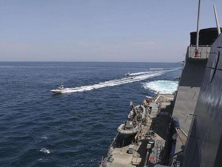 Schiffe der iranischen Revolutionsgarde in der Nähe eines Schiffes des US-Militärs im Persischen Golf bei Kuwait (Archiv).
