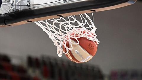 Ein Basketball landet im Korb.