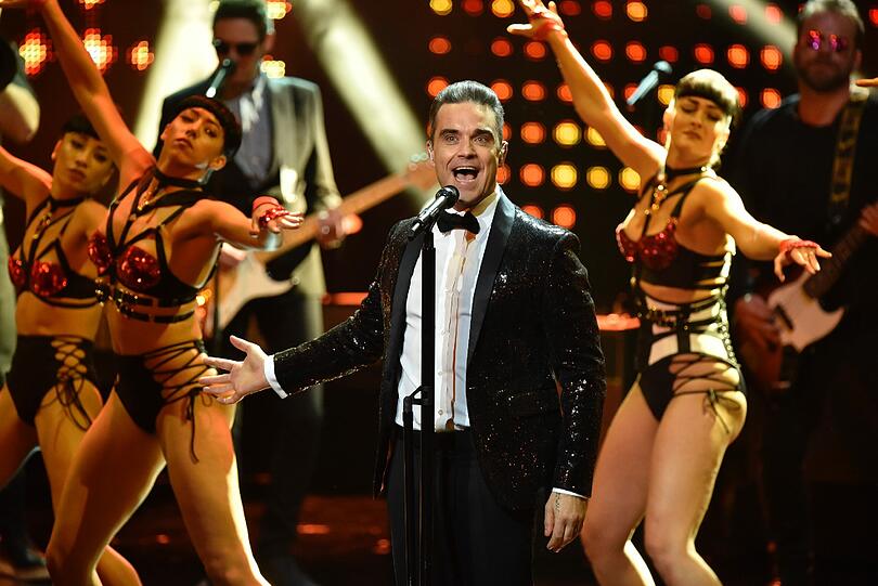 Robbie Williams steht bei der 68. Verleihung des Medienpreises Bambi auf der Bühne - im Hintergrund: Sehr viel Bein!
