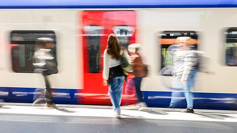 Fahrgäste stehen am Hauptbahnhof Hannover vor einer einfahrenden S-Bahn.