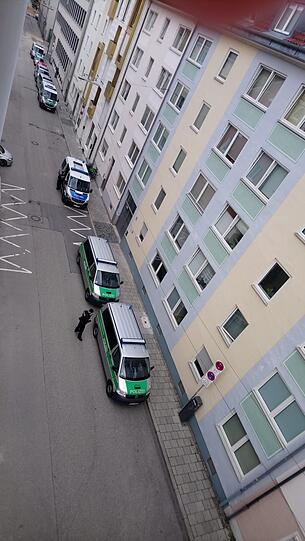 Einsatzfahrzeuge der Polizei stehen in einer Seitenstraße des Gerichtsgebäudes.