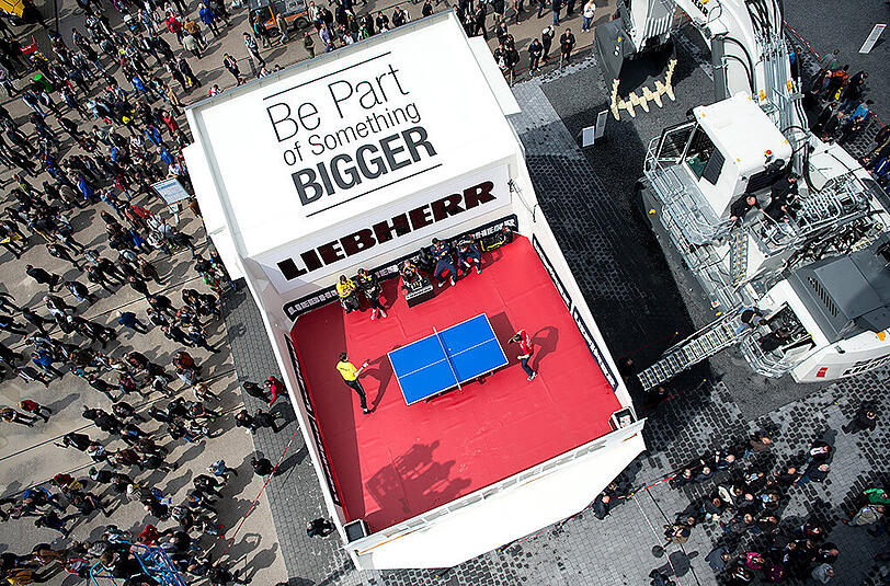 Außergewöhnliche Spielstätte auf der Bauma-Messe. Eine Tischtennis-Platte auf einem Muldenkipper.